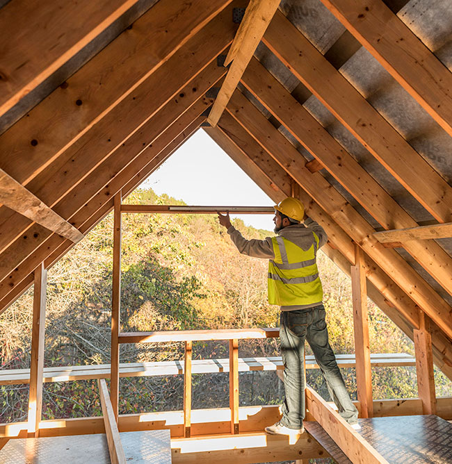 Carpintero reformando tejado de casa antigua